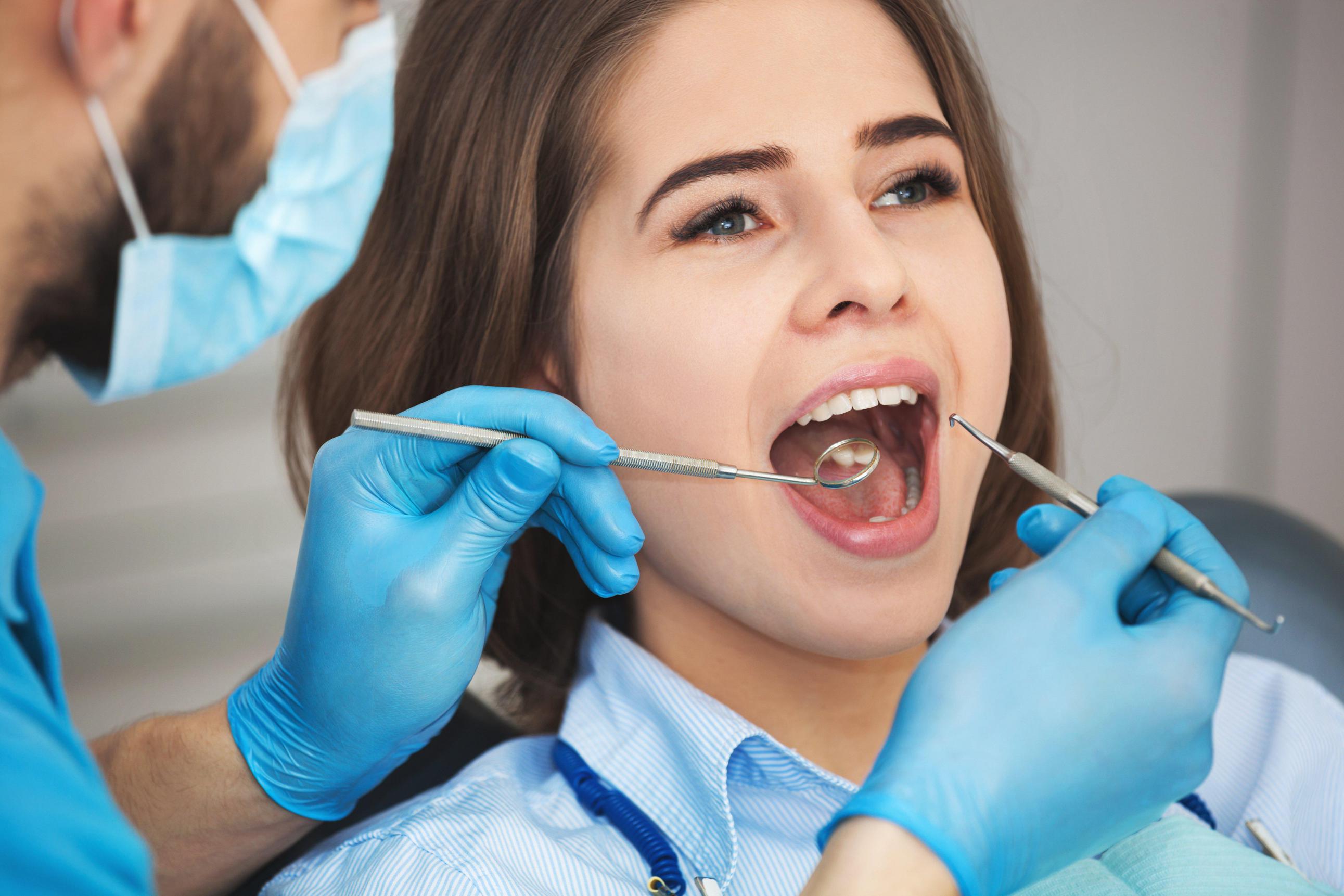 Shot of a young woman getting her teeth checked by a dentist.